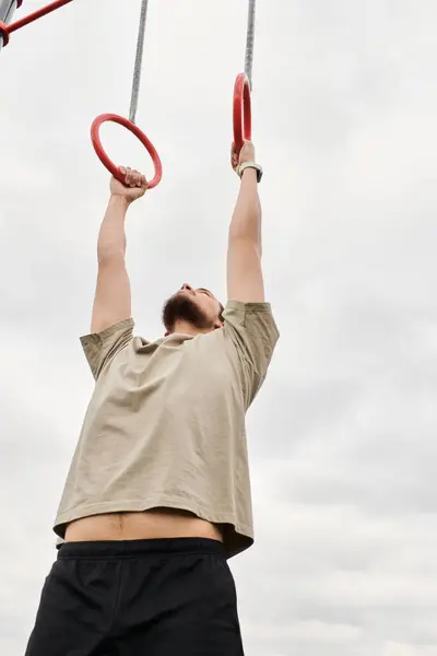 A bearded young man showcases his athleticism with an impressive outdoor exercise. — Stock Photo