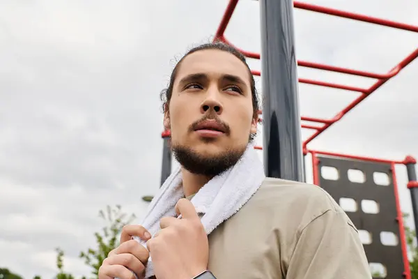 Joven con barba se dedica al ejercicio al aire libre, mostrando fitness y determinación. - foto de stock
