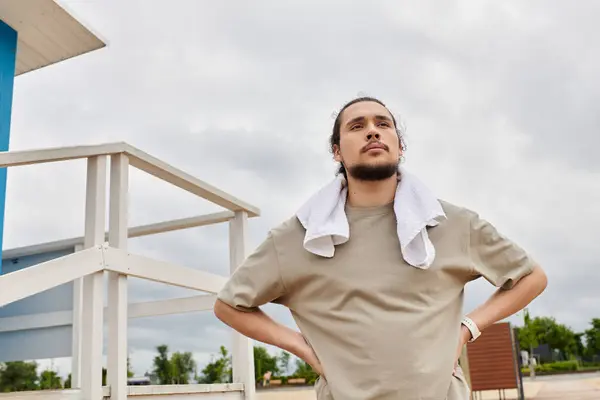 Sporty young man with a beard pauses during an outdoor workout session while contemplating goals. — Stock Photo