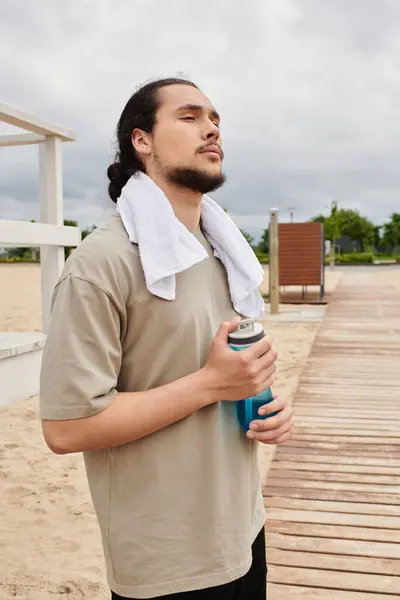 Sporty man with a beard rests after an intense workout in a natural setting. — Stock Photo