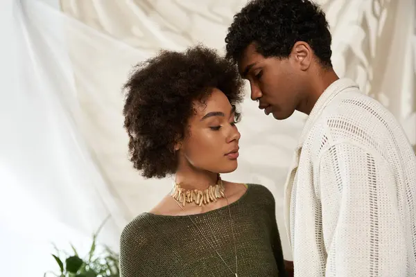 A young couple stands close, radiating love and connection in a stylish, intimate setting. — Stock Photo