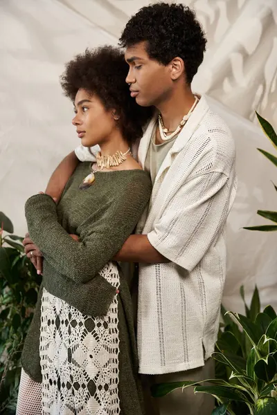 A young couple embraces lovingly in a serene setting filled with greenery and warmth. — Stock Photo
