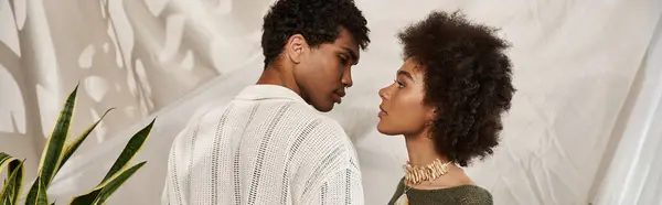 Young couple gazing into each others eyes, radiating love and connection in a cozy atmosphere. — Stock Photo