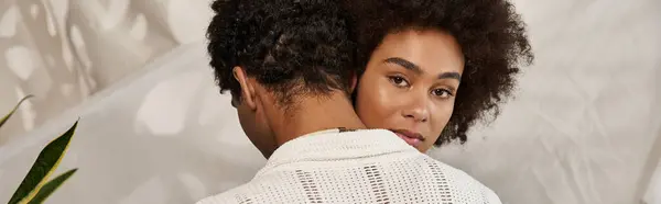 A couple embraces lovingly in an artistic, green filled backdrop. — Stock Photo