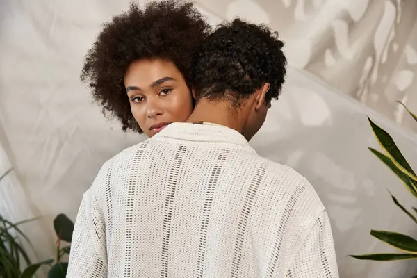 A young couple shares a tender moment, showcasing their love amidst greenery and soft textures. — Stock Photo