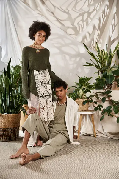 In a green indoor space, a couple shares a sweet moment in their stylish outfits. — Stock Photo