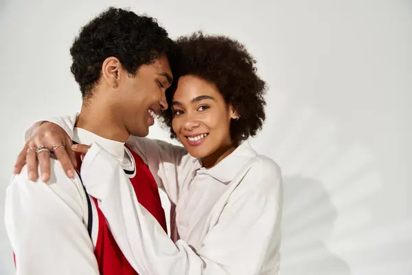 Stylish young couple embraces warmly, radiating love and happiness in their aesthetic attire. — Stock Photo