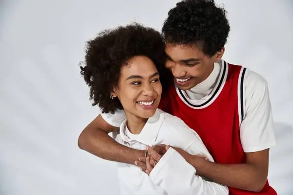Two young lovers express affection, showcasing their style and happiness in a bright environment. — Stock Photo