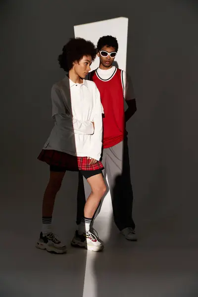 Stylish young couple showcases their love and aesthetic charm amidst dramatic lighting and shadows. — Stock Photo