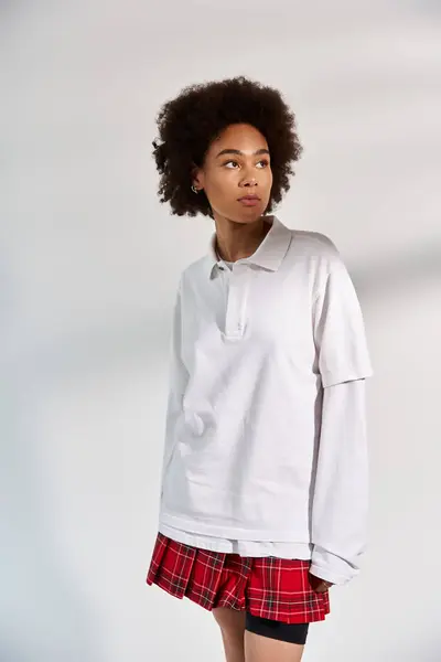 A young woman posing on white backdrop while in stylish sporty attire. — Stock Photo