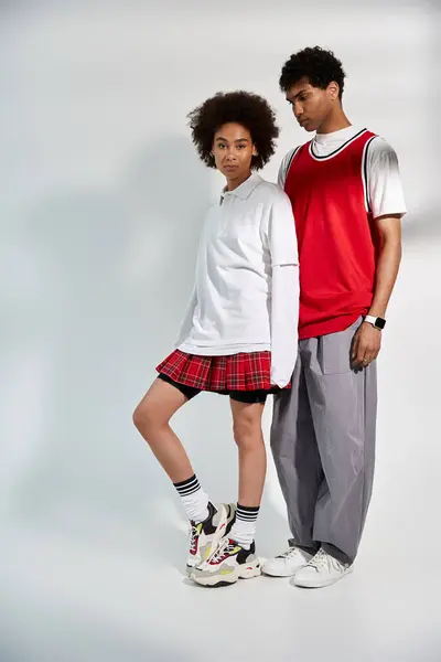 A young couple stands close, showing love through stylish outfits and confident poses. — Stock Photo