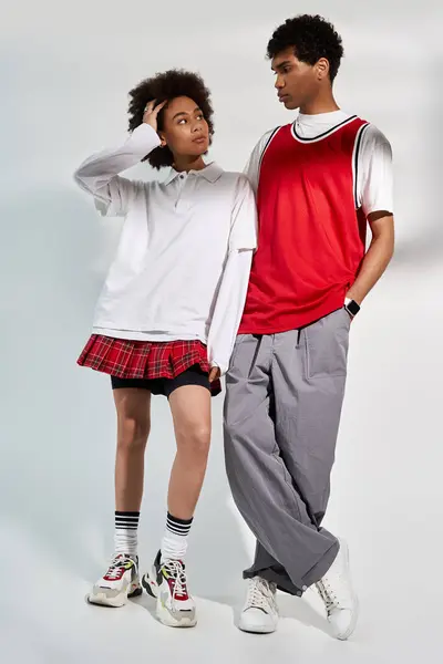 A trendy young couple stands close, showcasing their love in a softly lit studio. — Stock Photo