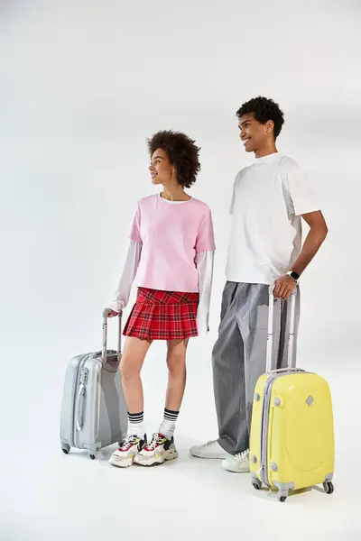 Loving couple poses with vibrant luggage, expressing excitement for their upcoming journey. — стоковое фото