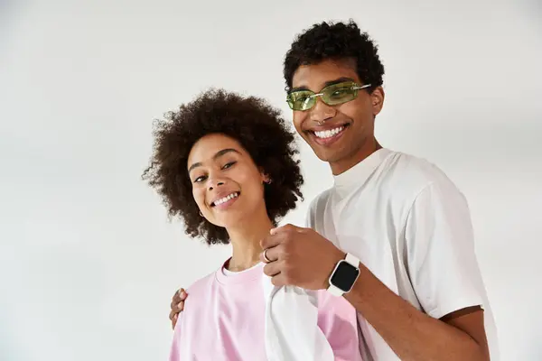 A young couple laughs while playfully posing together, showcasing their unique style and bond. — Stock Photo