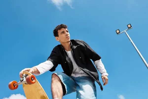 A young guy skillfully balances on his skateboard while enjoying the sunny day in the park. — Stock Photo