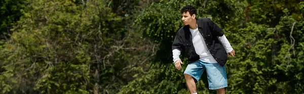 A young man skillfully skates on a fresh green lawn in a vibrant park setting. — Stock Photo