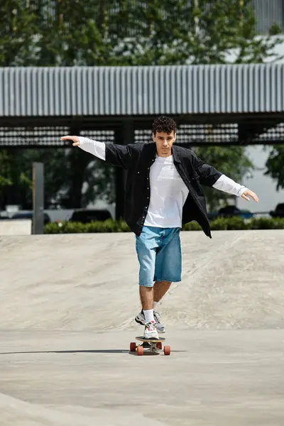 A young man skates in a vibrant park, balancing skillfully while enjoying the sunshine. — Stock Photo