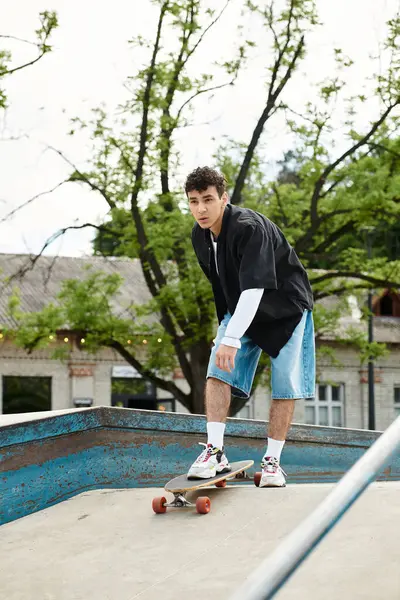 A young man shows off his skateboarding skills at a park while enjoying the outdoors. — Stock Photo