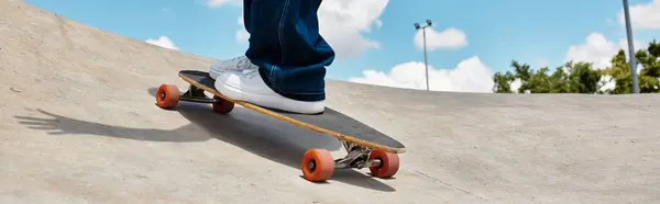 A young man skates effortlessly at the park under a bright blue sky on a sunny day — Stock Photo