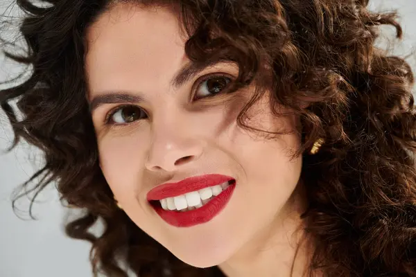 A young woman with curly hair showcases her summer style with a bright smile and vibrant energy. — стокове фото