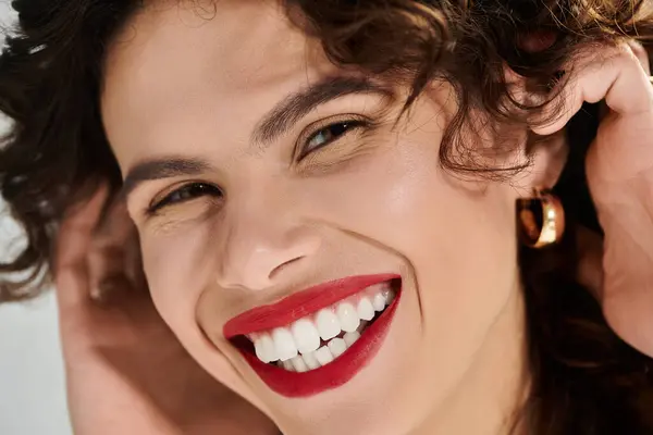 A joyful young woman flaunts her beauty in a vibrant summer outfit, smiling brightly. — стокове фото