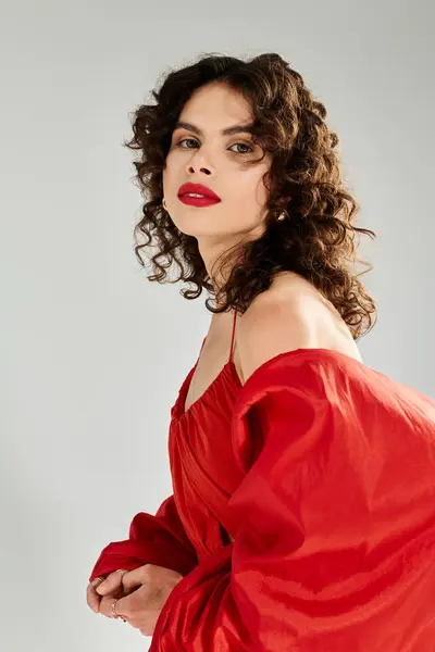 Young woman with curly hair showcases a vibrant red outfit while radiating summer joy. — Stock Photo