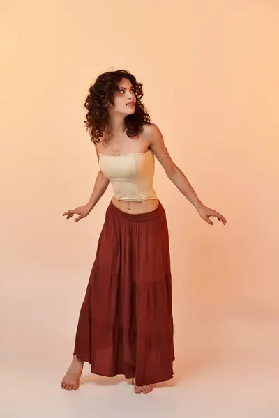 A beautiful young woman dressed in summery attire is playfully posing with an elegant stance. — Stock Photo