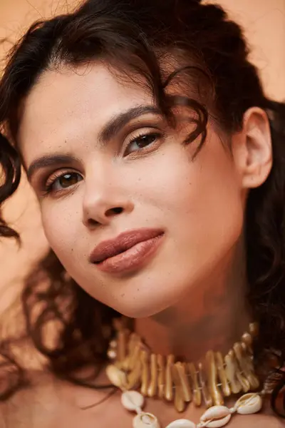 Young woman with curly hair showcases seasonal style adorned in chic accessories. — стокове фото