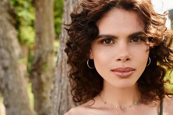 A young woman radiates beauty in summer fashion against a lush green backdrop. — Stock Photo
