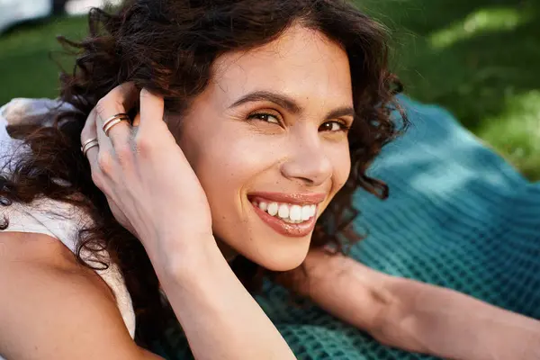 A young woman relaxes in the sun, smiling and enjoying summer in elegant attire. — Stock Photo