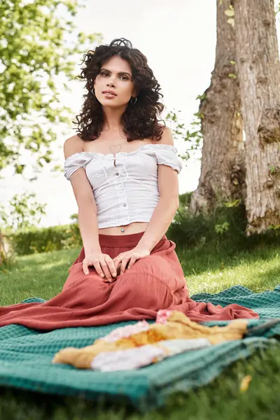 Young woman enjoys a peaceful moment in a lush garden wearing chic summer clothes, radiating style. — Stock Photo