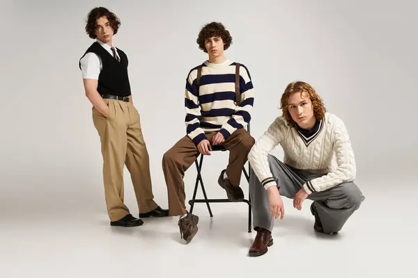 Trois jeunes hommes à la mode posent ensemble, exprimant leurs styles uniques dans un espace contemporain. — Stock Photo