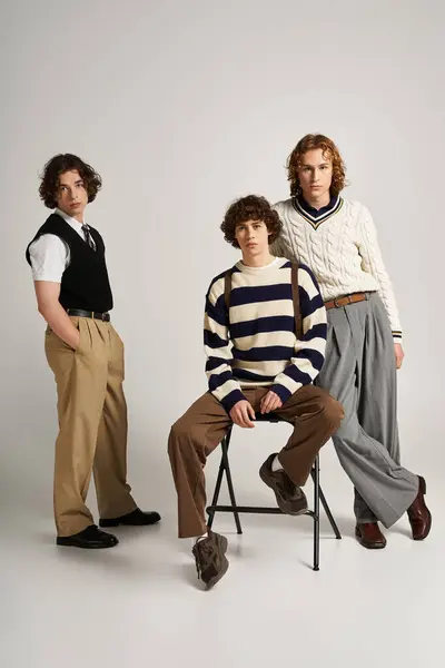 Three young men pose together in a stylish outfit showcase, embracing modern fashion trends. — Stock Photo