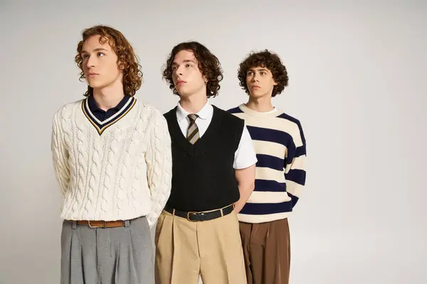 Three stylish young men pose in a bright studio, showcasing their unique looks. — Stock Photo