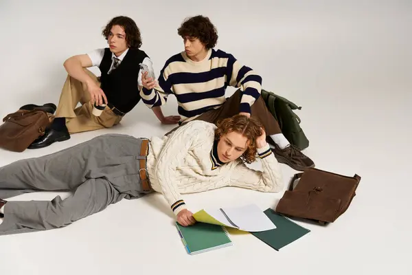 Three fashionable young men engage in a fun and creative gathering in a bright studio. — Stock Photo