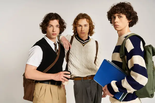 Three young men showcase modern style with accessories in a bright setting. — Stock Photo