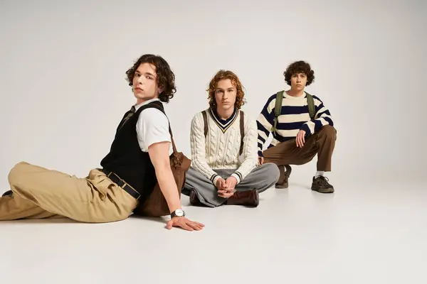 Three fashionable young men gather in a creative space, expressing their unique styles together. — Stock Photo