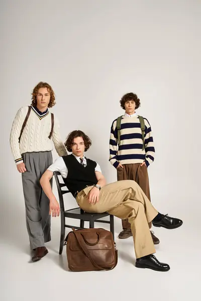 Trois jeunes hommes posent dans un studio lumineux, mettant en valeur leurs tenues modernes et leurs styles uniques. — Stock Photo
