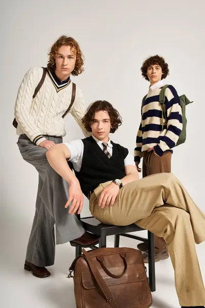 Three young men dressed in trendy outfits share a fun and relaxed pose while showcasing their style. — Stock Photo