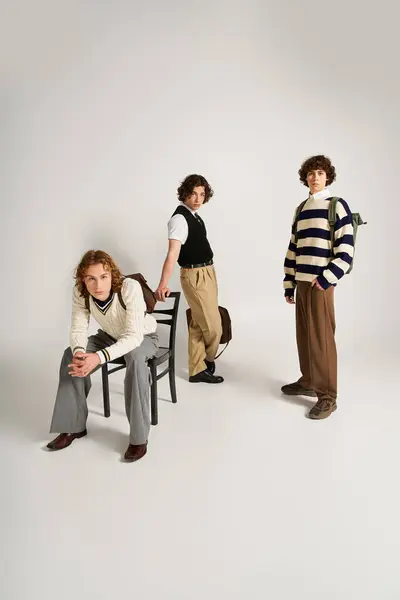 Three stylish young men showcase their fashion sense while posing in a vibrant studio space. — Stock Photo