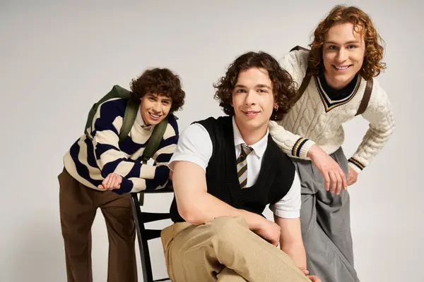 Three fashionable young men display their unique styles while posing playfully in a cozy space. — Stock Photo