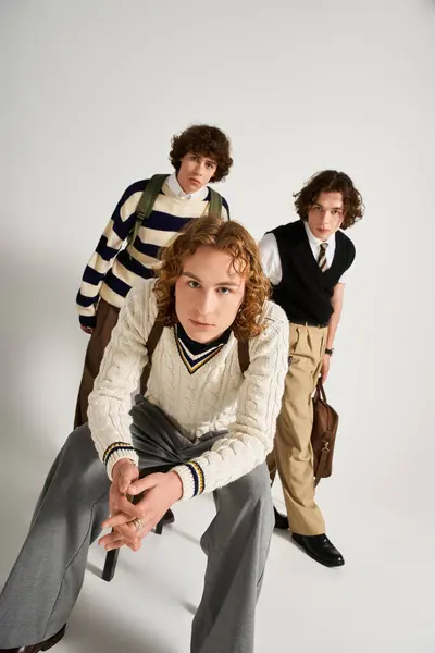 Three young men express individuality and friendship through vibrant styles in a chic studio. — Stock Photo