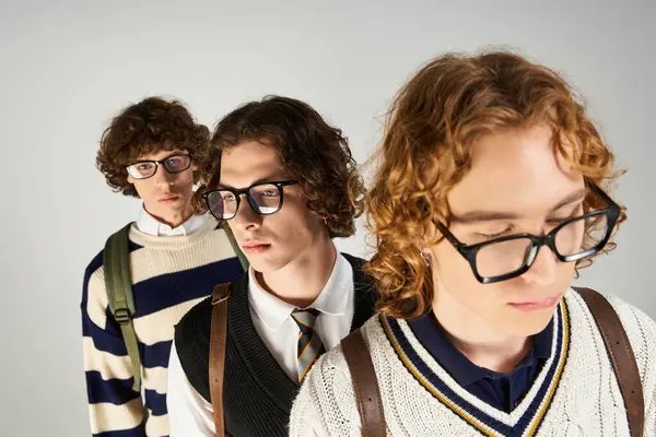 Three fashionable young men pose closely, highlighting their trendy outfits and stylish glasses. — Stock Photo