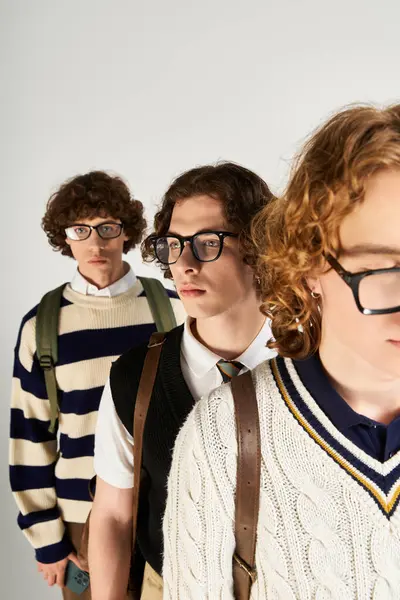 Trois jeunes hommes élégants posent de façon ludique, mettant en valeur leur mode unique. — Photo de stock