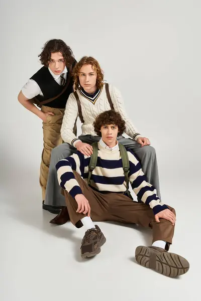 Three young men display their unique fashion styles, posing confidently in a vibrant studio. — Stock Photo
