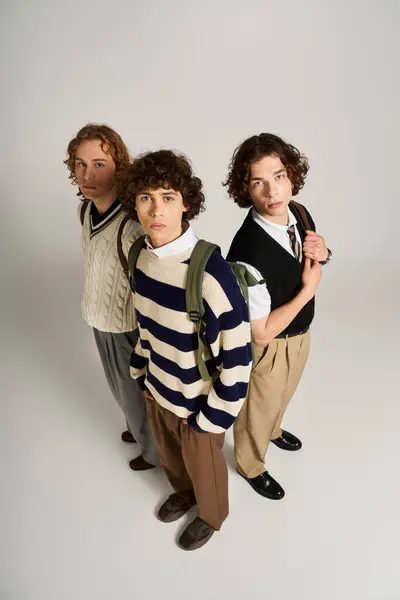 Three friends display their unique styles while posing together against a neutral backdrop. — Stock Photo