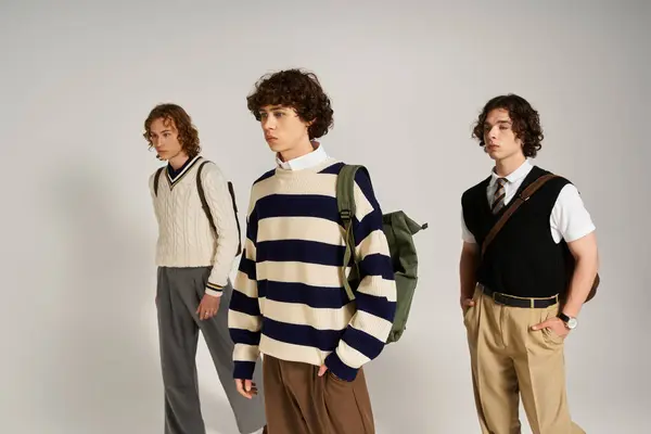 Three trendy friends confidently pose in a modern studio, showcasing their unique styles. — Stock Photo
