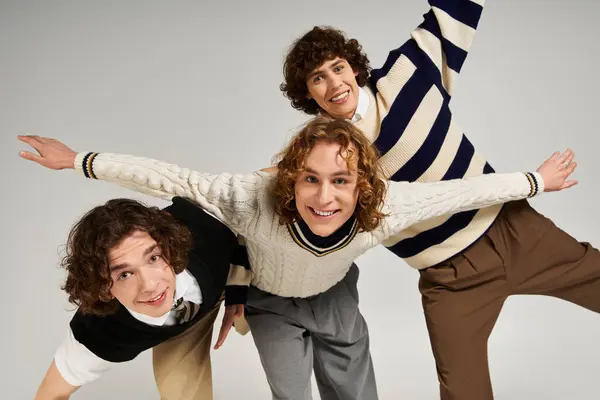 Three young men display unique styles together, exuding confidence in a creative indoor space. — Stock Photo