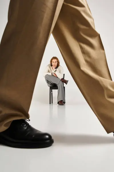 Two stylish young men pose confidently, showcasing their unique looks in a minimalist setting. — Stock Photo