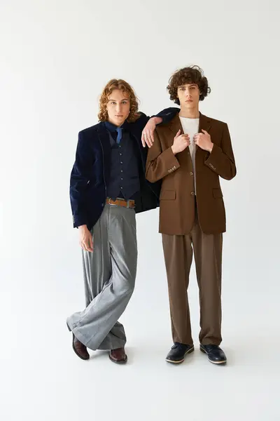 Deux jeunes hommes se tiennent en tenue chic, exprimant un sentiment d'amitié et de style. — Stock Photo